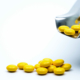 View of yellow-coated tablets falling out out of a perforated coating pan